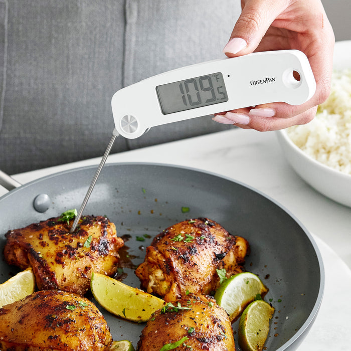 Cooked chicken in a roasting bundle checked with a digital thermometer reading 109°F in a metal pan.