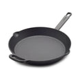 The Bobby Flay by GreenPan 12" Cast Iron Frypan, shown in black with a long handle, small helper handle, and two pour spouts on a white background, offers a spacious cooking surface—perfect for any meal.