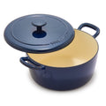 Cobalt blue enameled Dutch oven with lid slightly open, revealing its cream-colored interior.