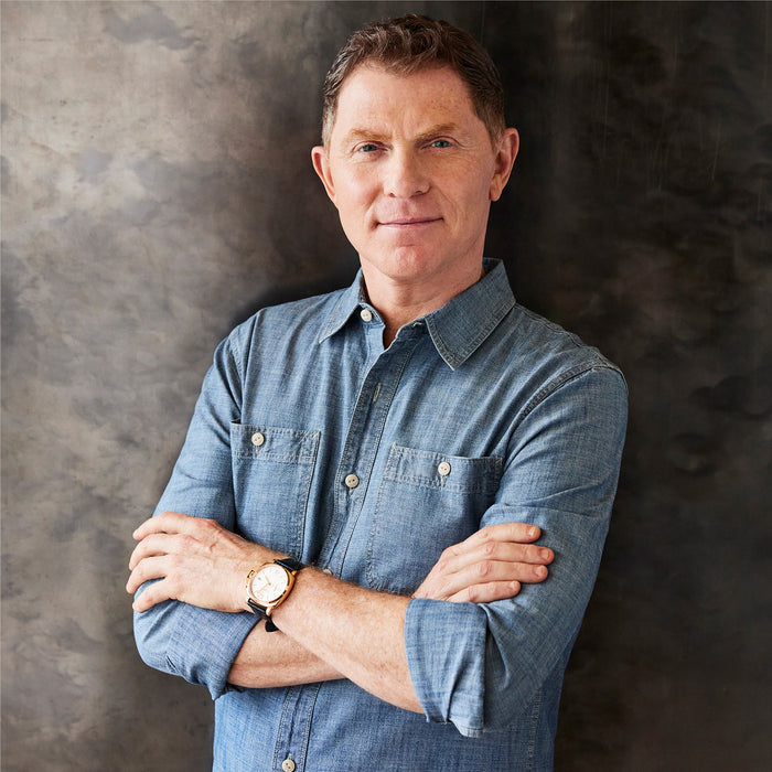 Man in a denim shirt stands with Bobby Flay next to a GreenPan 12-inch nonstick frypan with lid.