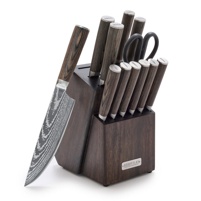The Bobby Flay by GreenPan Stainless Steel 13-Piece Knife Block Set includes patterned Damascus design knives with dark wood handles, kitchen shears, a sharpening rod, and a chef’s knife displayed outward against the wooden block.