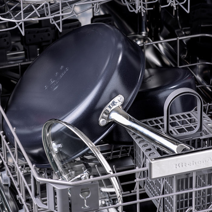 Black ceramic nonstick 8-inch frypan with glass lid placed on the top rack of a dishwasher.