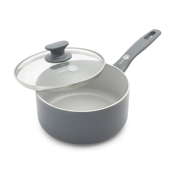 Gray ceramic 2.25-quart saucepan with glass lid, two handles with hanging holes, lid resting partly on the rim.