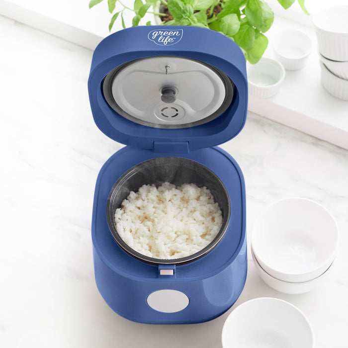 Blue rice and grains cooker with ceramic nonstick pot, 4-cup capacity, open on a white countertop.