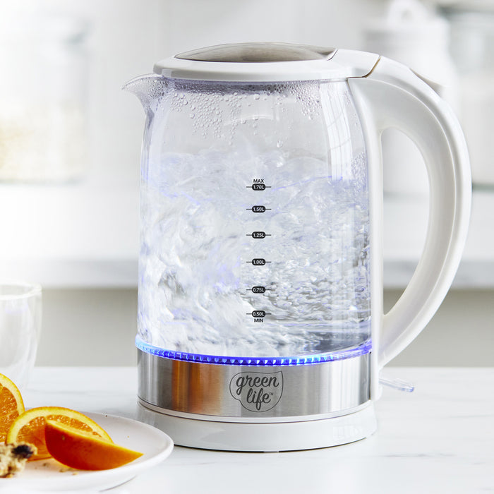 White glass electric kettle, 1.7L, on a white counter beside sliced oranges.