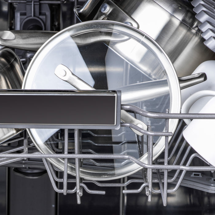 Dishwasher with stainless steel pots, an 8 GreenPan glass lid, and assorted kitchenware on metal racks.