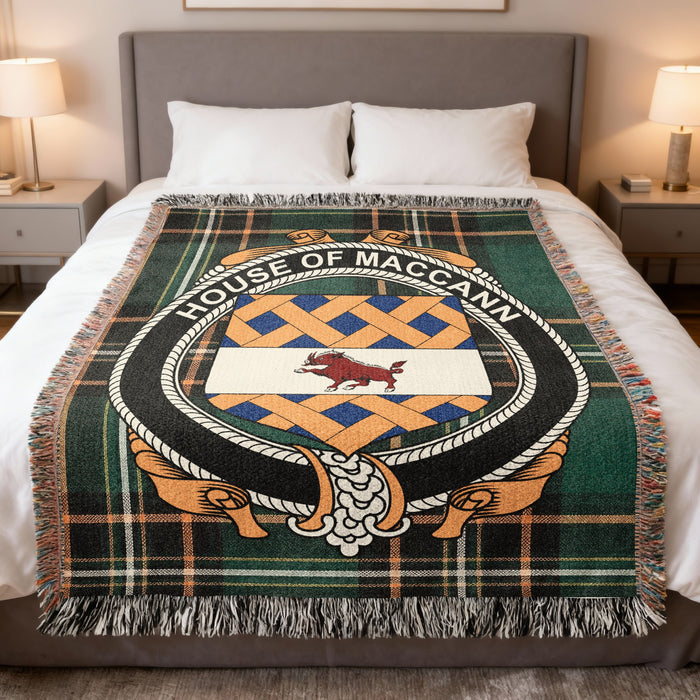 House of MacCann family crest woven blanket on an Irish National Tartan background, displayed on a bed