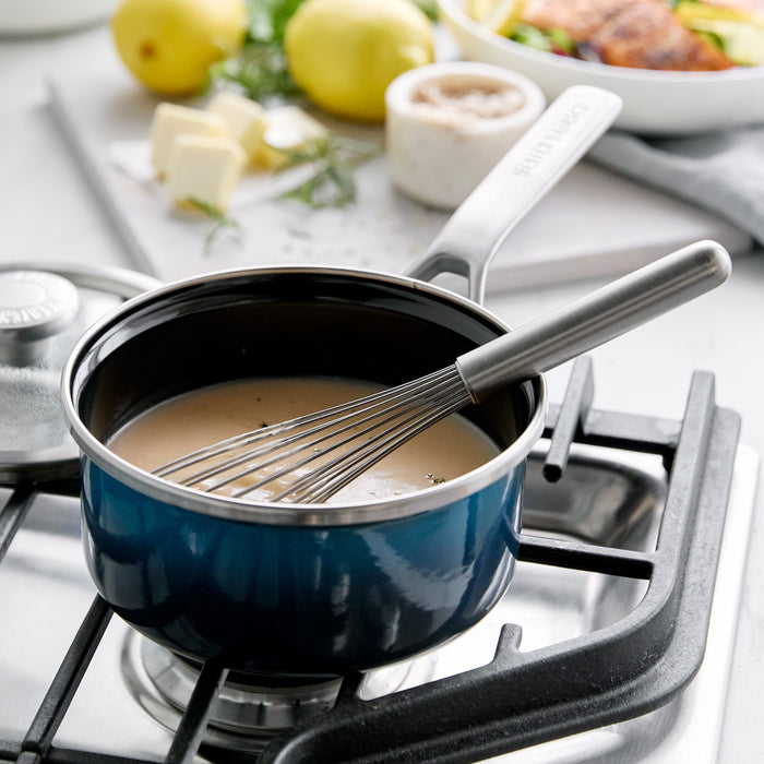 Aegean Teal enameled steel 1.5-quart saucepan with sauce, shown on a stovetop.