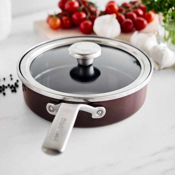 Chocolate brown enameled steel sauté pan with lid, 2-quart size, shown on a countertop.