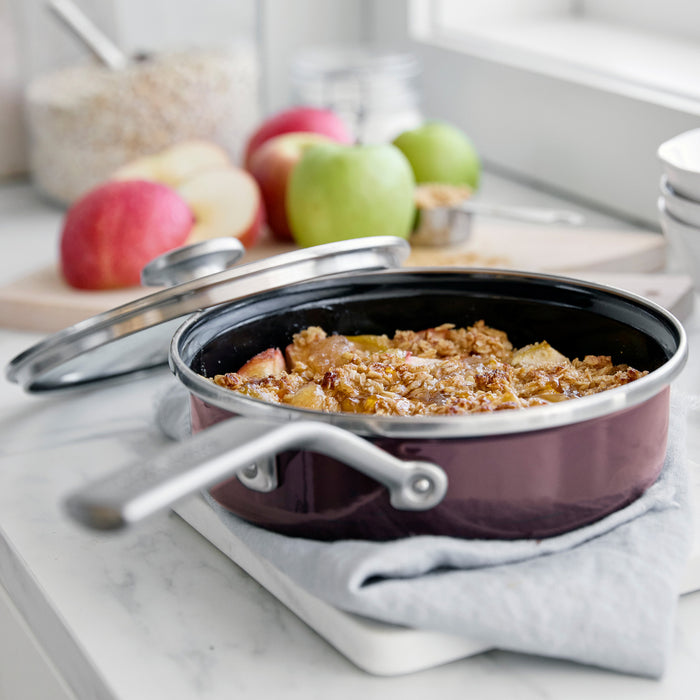 Chocolate Truffle enameled steel sauté pan, 2-quart size, filled with baked apple crisp on a kitchen counter.