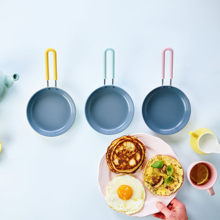 Yellow ceramic nonstick 5-inch frypan above a plate with pancakes, banana toast, and a fried egg.