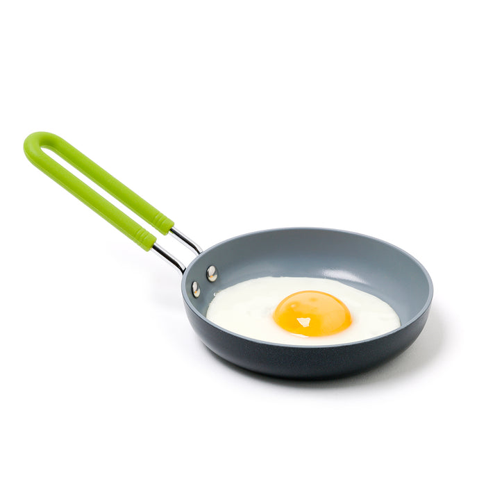 Green 5-inch ceramic nonstick frypan with a fried egg inside, shown on a white background.