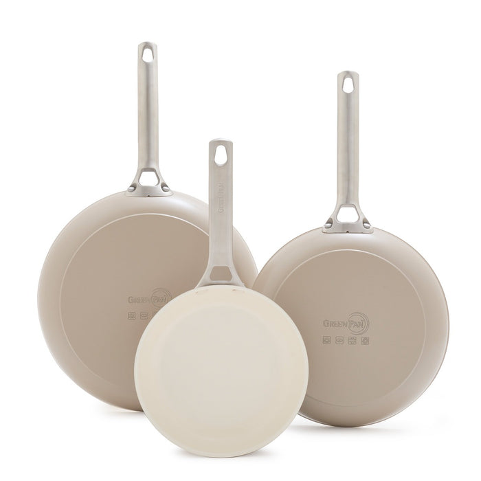 Set of three taupe ceramic frypans with metal handles 8″, 10″, 12″ standing upright, bottoms visible.