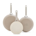 Set of three taupe ceramic frypans with metal handles 8″, 10″, 12″ standing upright, bottoms visible.