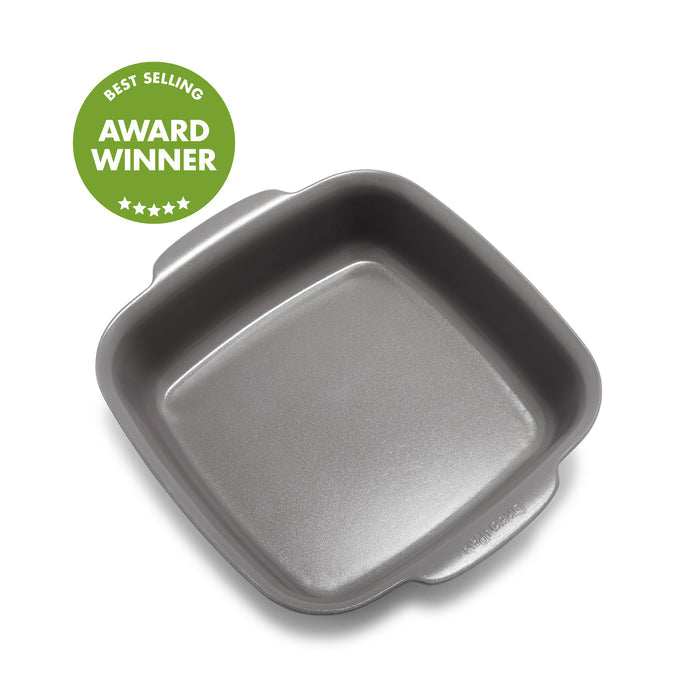 Gray ceramic square baker with nonstick finish next to a green award badge featuring stars.