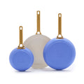 Set of three ceramic frying pans with gold handles: two blue and one white. Sizes are 8, 10, and 12.