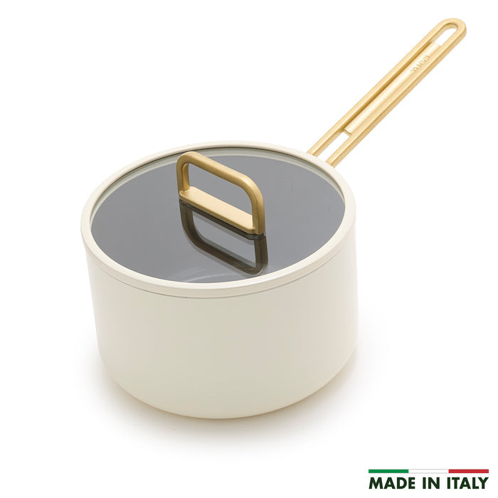 White ceramic 4-quart saucepan with lid and gold handle, shown in Carrara white finish.