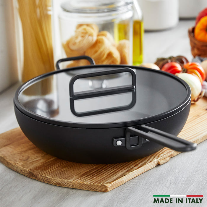 Milano Black ceramic nonstick pan, 6.5-quart size, on a wooden board in a kitchen setting.