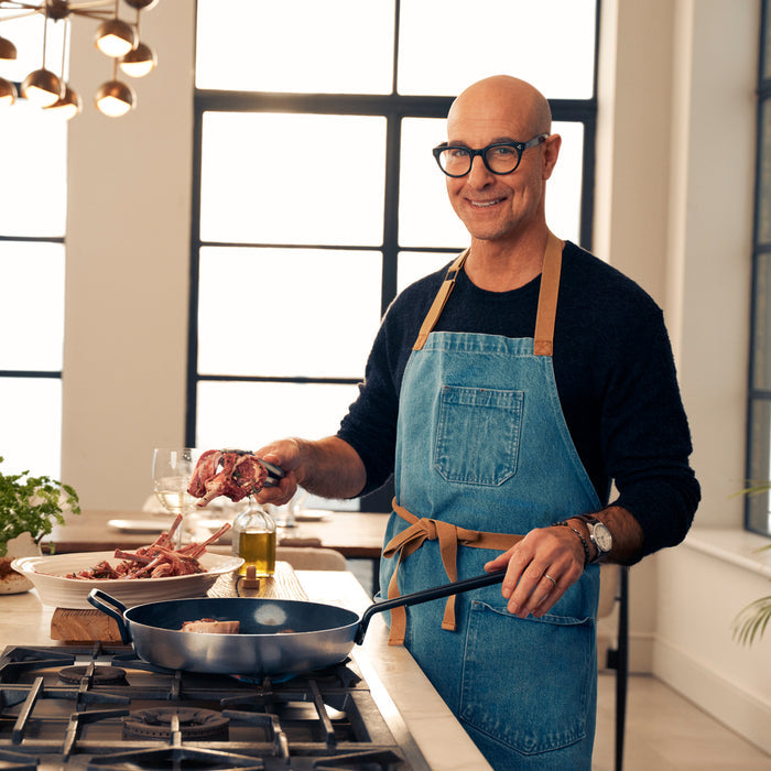 Man cooking meat in a stainless steel ceramic nonstick frypan in a modern kitchen.