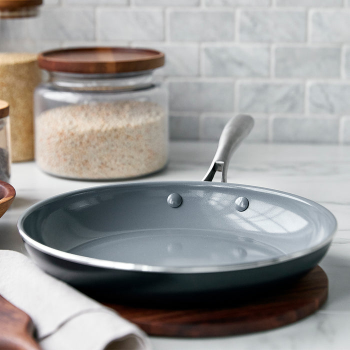 Ceramic nonstick 10-inch frypan on a kitchen counter with jars of rice and a towel in the background.
