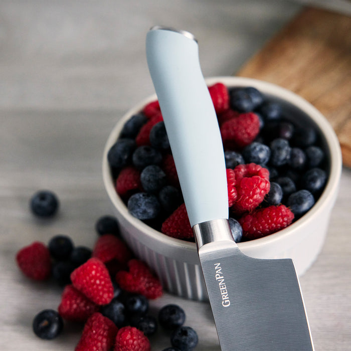 Blueberries and raspberries in a bowl with a Blue Haze titanium cutlery knife resting on the berries.