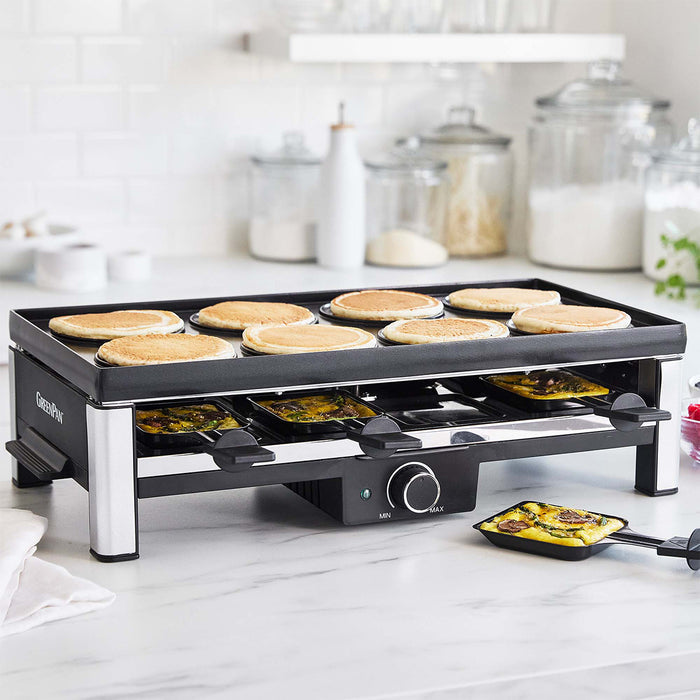 Countertop grill with pancakes cooking on the top plate and mini omelets below, set in a bright kitchen.
