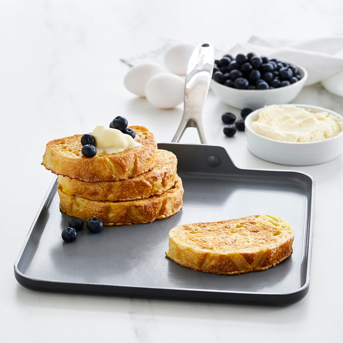 French toast with cream and blueberries on a grey ceramic nonstick 11-inch square griddle.