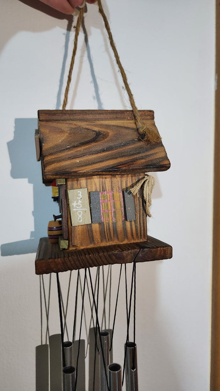 wooden house-shaped wind chime with metal tubes