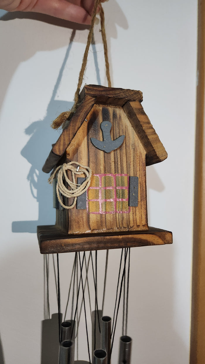 wooden house-shaped wind chime with metal tubes