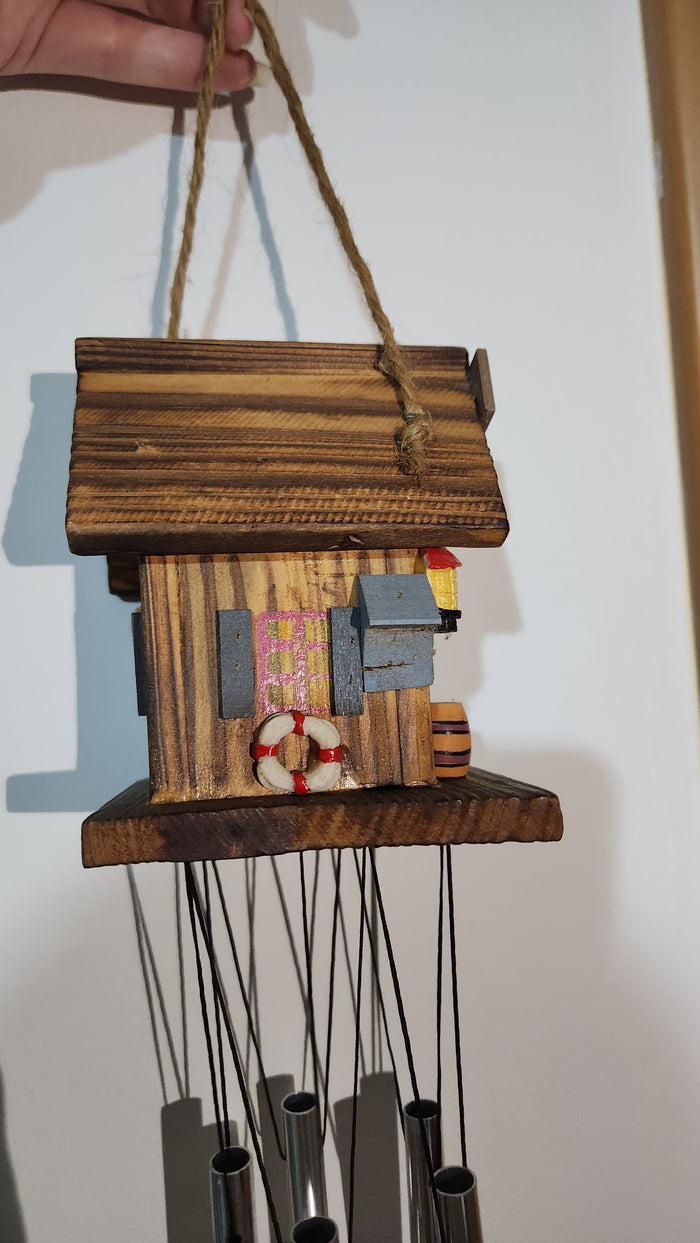 wooden house-shaped wind chime with metal tubes